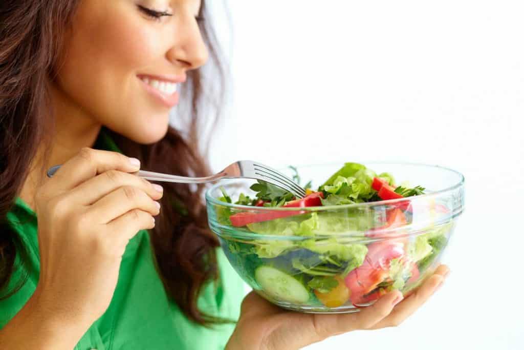 image of smiling woman eating a salad