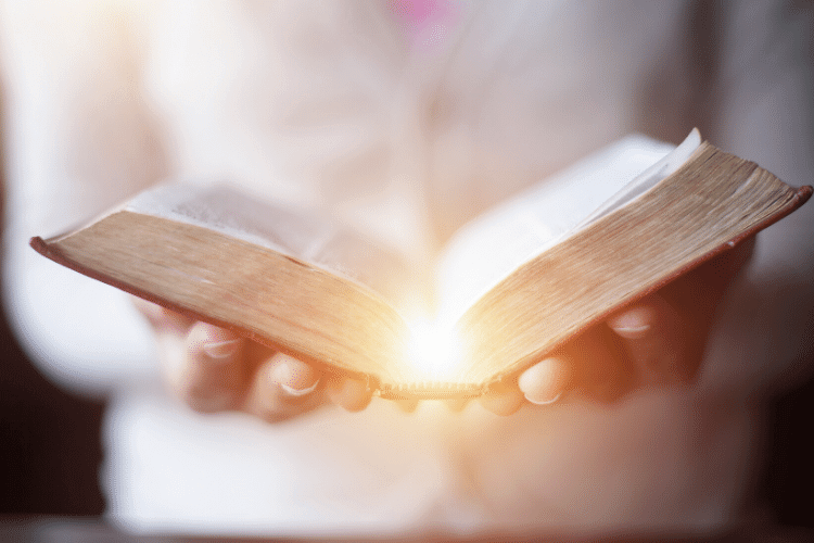 hands holding an open Bible