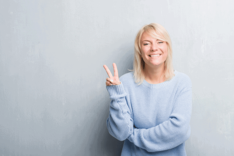 smiling woman holding up two fingers