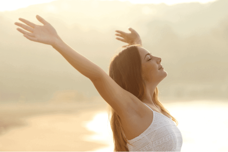 Woman raising arms on beach