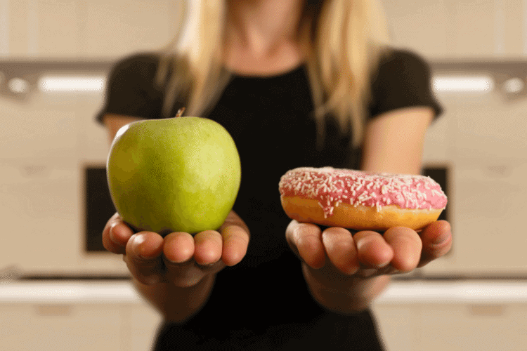 Woman holding apple and donut