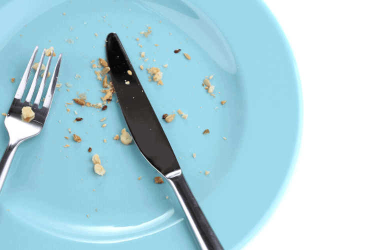 photo of empty blue plate with crumbs, a fork and knife resting on top