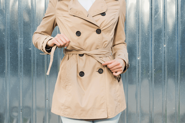 image of woman tying the belt on her trench coat