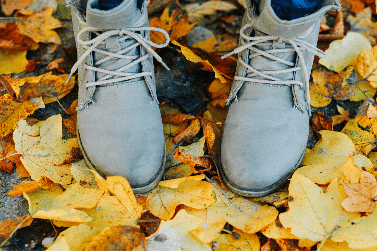 image of women's boots on top of autumn leaves