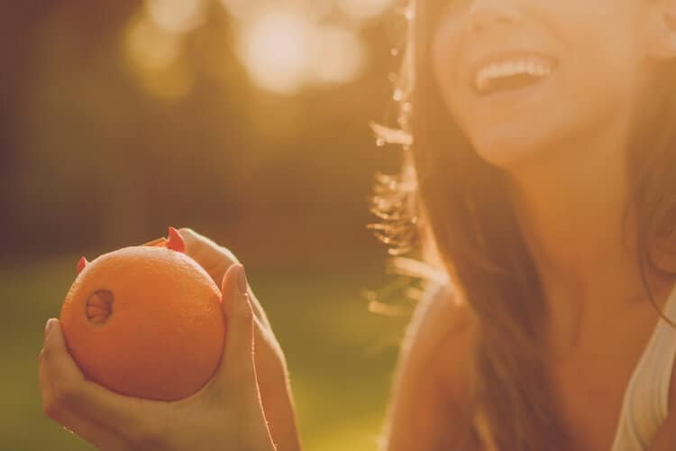 picture of woman eating orange