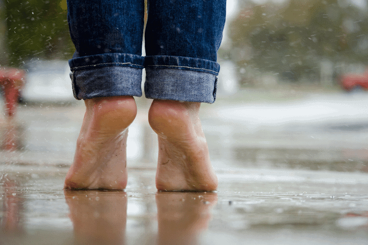 image of woman's bare feet standing in a puddle