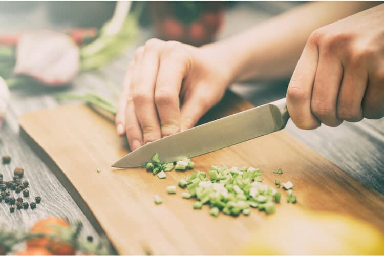 image of person chopping vegetables to prepare a health meal 