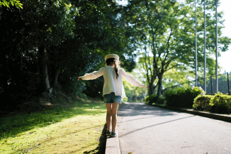 little girl balancing on curb