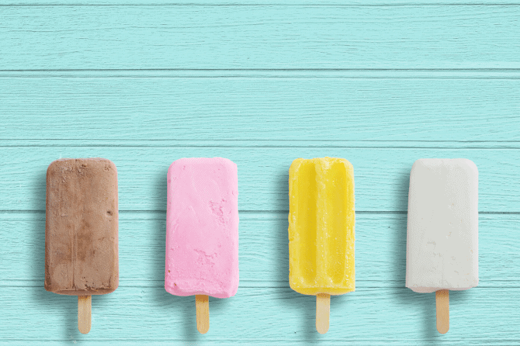 four colored popsicles on a turquoise background