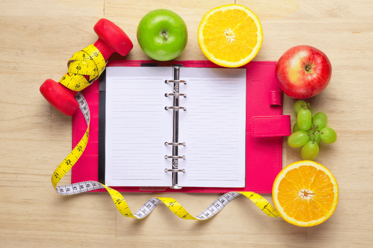 open planner with fruit and weight loss equipment
