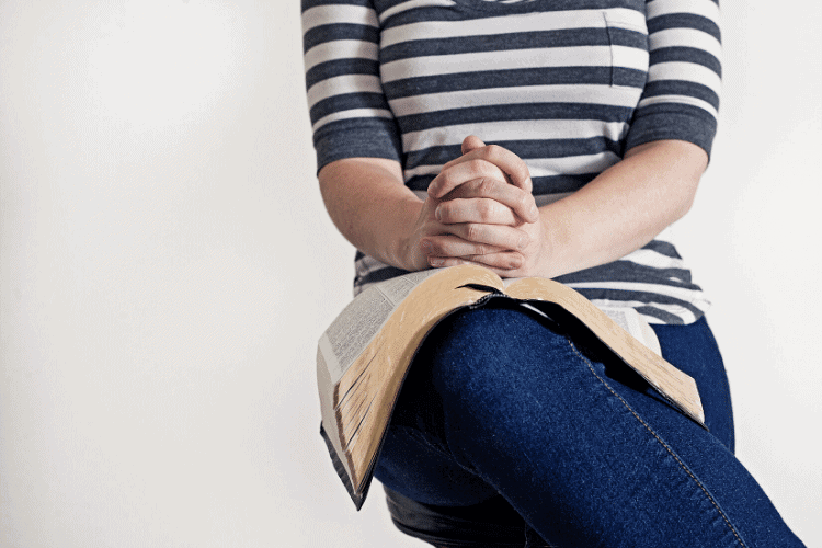 image of woman with Bible on her lap and hands folded