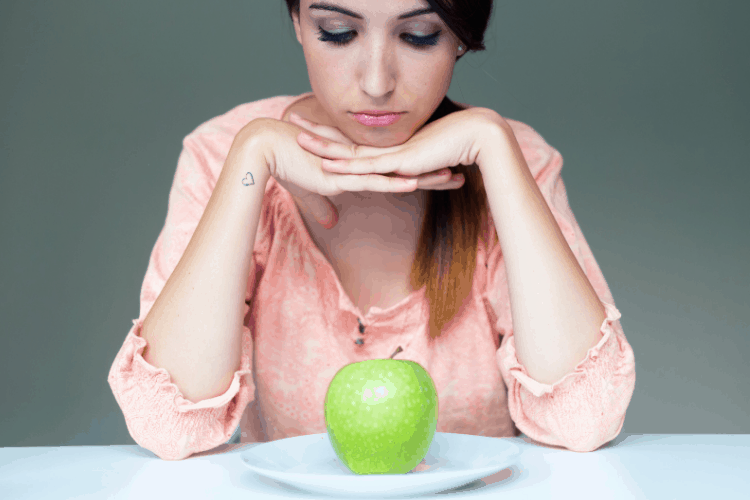 woman looking at an apple