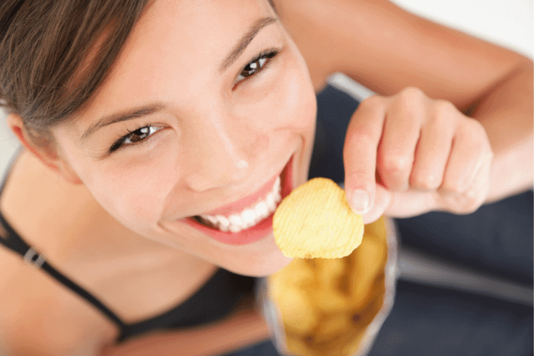 happy woman eating a potato chip