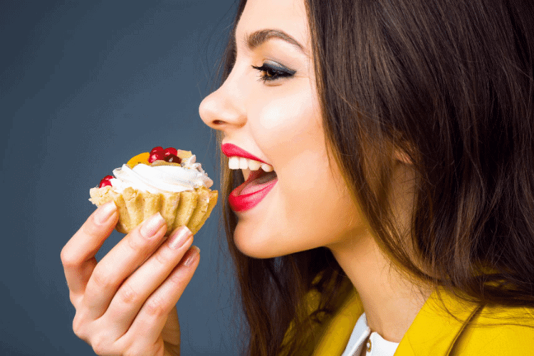 happy woman eating a mini pie